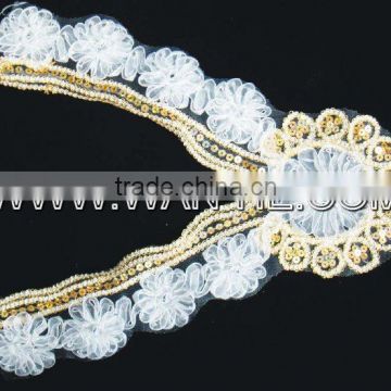 white flower with gold sequin garment accessory