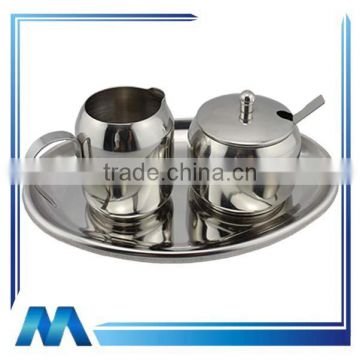 stainless steel milk jug and sugar set on tray