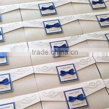Glamorous & charming white pocket fold wedding invitations with royal blue bow & rhinestone decrations