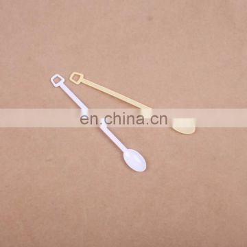 white mini disposable plastic stirrer coffee spoon with hole