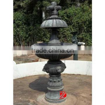 antique black stone fountain with lion head carving