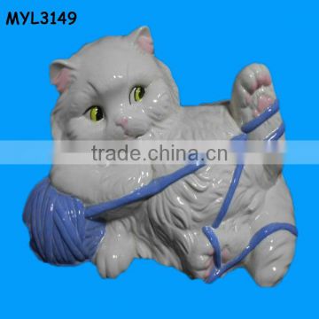 ceramic fat cat statue playing with a blue yarn ball