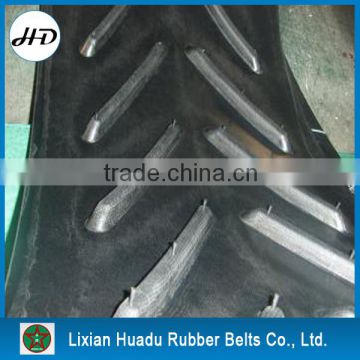 Skid-resistant chevron conveyor belt with moulded cleats for incline angle conveying