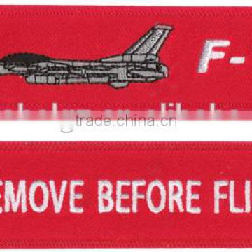cheap custom embroidered remove before fligh textile keychain