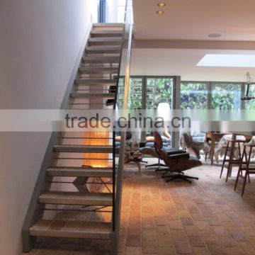 Modern staircase with structural glass balustrade and stainless steel tray type treads.